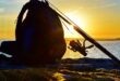 zaino e canna da pesca su scoglio al tramonto